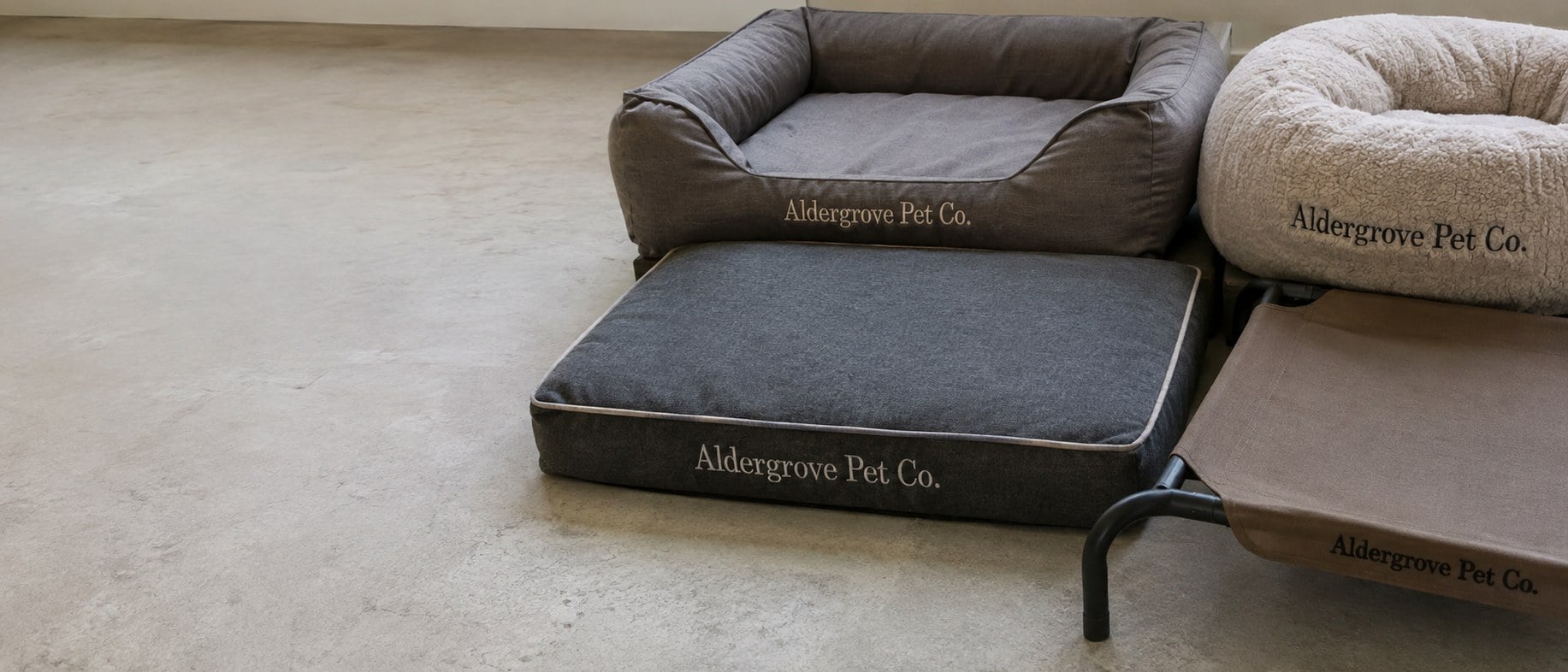 Custom printed dog beds with a logo stacked in a kennel room